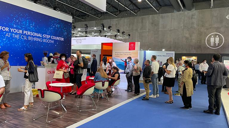 A line of people going to a CSL Behring Booth at a convention